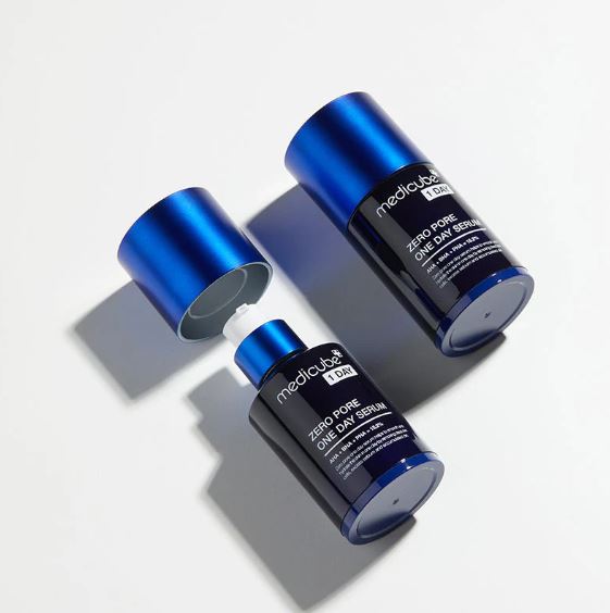 Two blue and black skincare products on a gray background