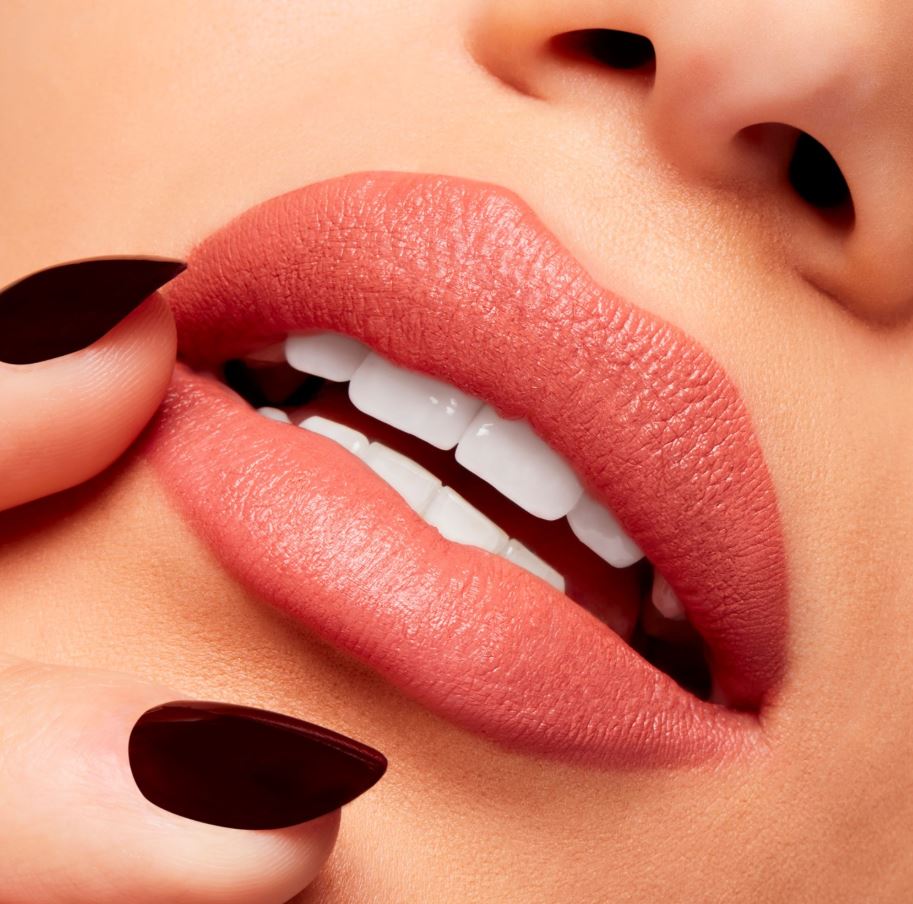 Close-up of a person's lips with red lipstick and dark nail polish.