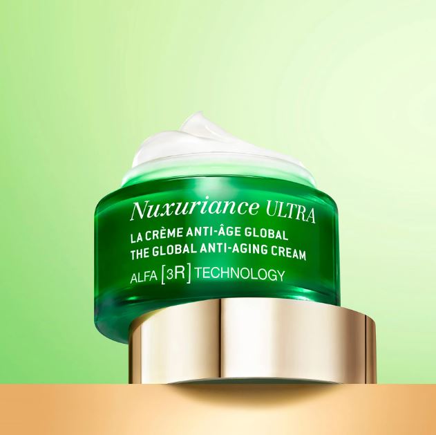 Green skincare cream jar with gold cap on a green background