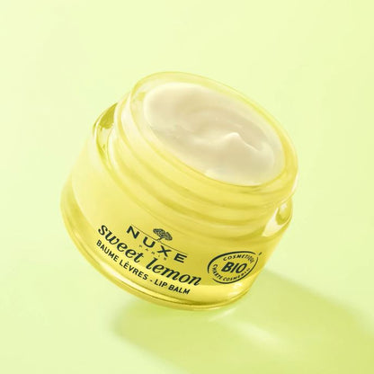 Nuxe sweet lemon lip balm jar on a light green background