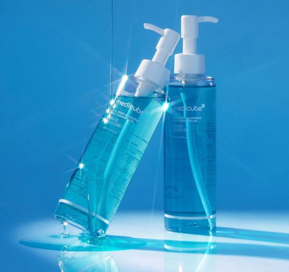 Two bottles of Medcube skincare product on a blue background