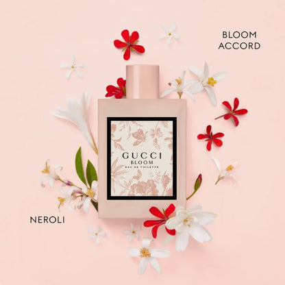 Gucci Bloom Accord perfume bottle with flowers on a pink background