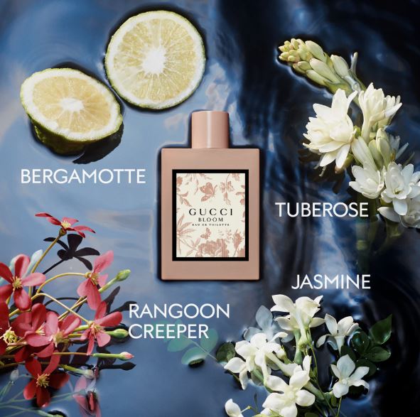 Gucci Bloom perfume bottle with floral elements and text labels on a dark background