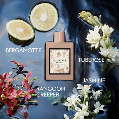 Gucci Bloom perfume bottle with floral elements and text labels on a dark background