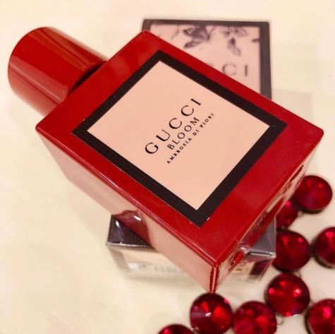Red Gucci Bloom perfume bottle on a light background