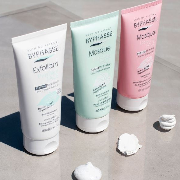 Three Byphasse skincare products on a gray surface with visible cream.