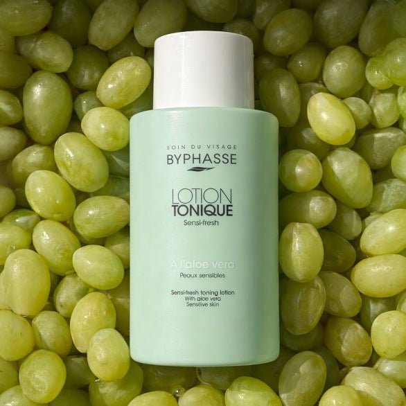 Bypasse lotion tonique bottle on a bed of green grapes