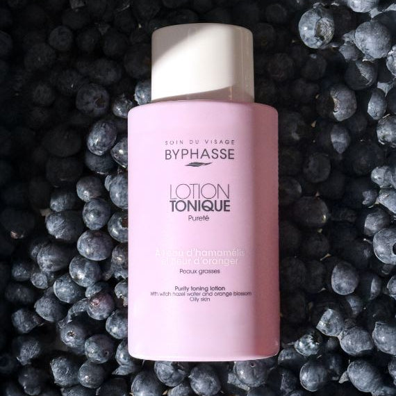 Byphasse Lotion Tonique bottle on a background of dark berries