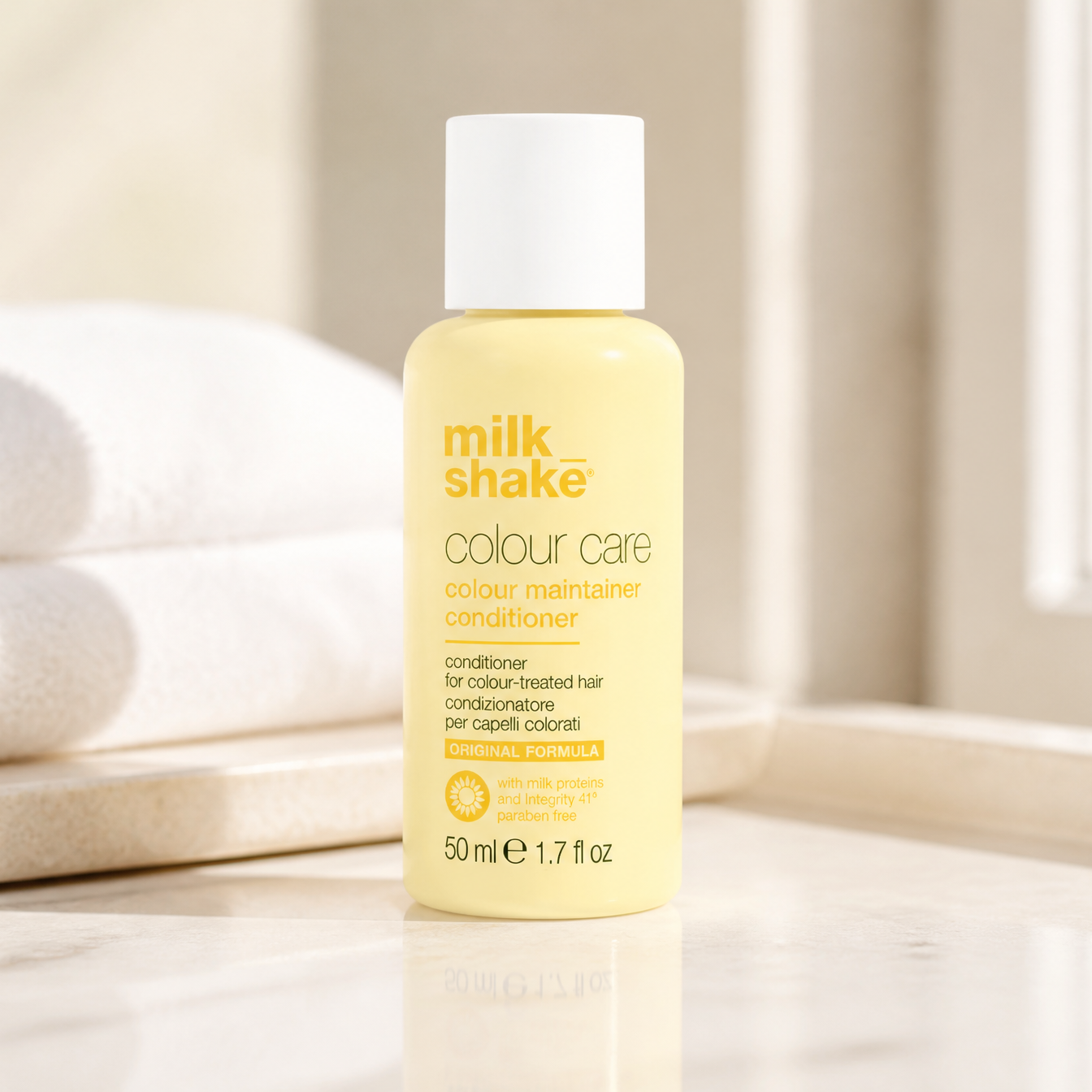 Milk Shake Colour Care conditioner bottle on a neutral background with towels.