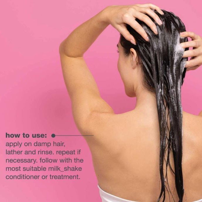 Person applying shampoo to their hair with a pink background and text on how to use shampoo.