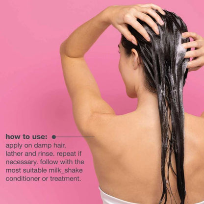 Person applying shampoo to their hair with a pink background and text on how to use shampoo.