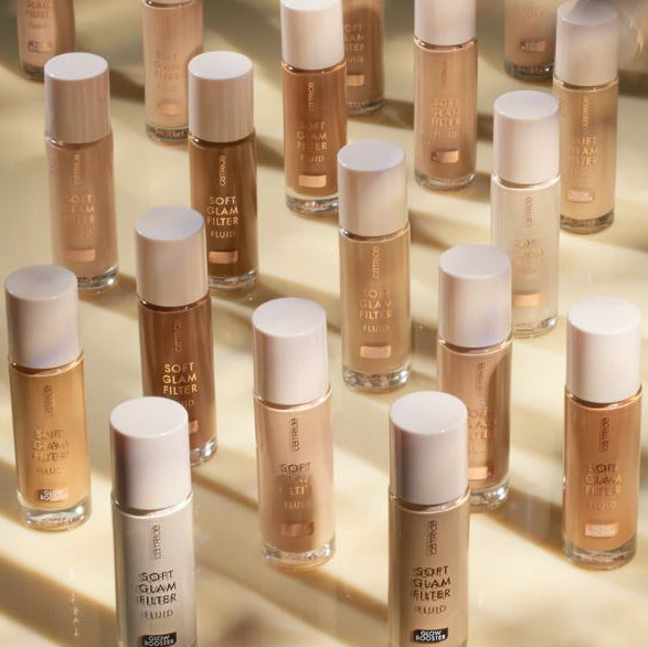 Multiple bottles of a cosmetic product with white caps on a reflective surface.