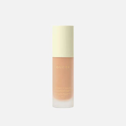 Cosmetic bottle with Gucci branding on a light beige background