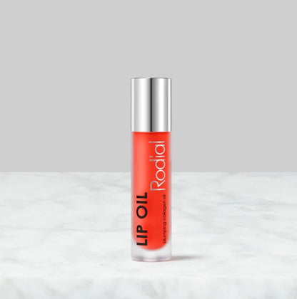 Lip oil with silver cap and red label on a white background