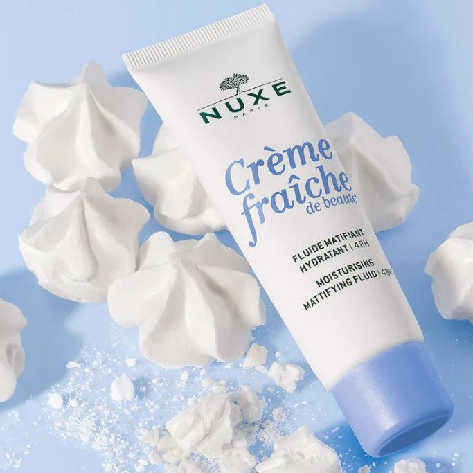Nuxe Crème Fraçe skincare product with whipped cream on a blue background
