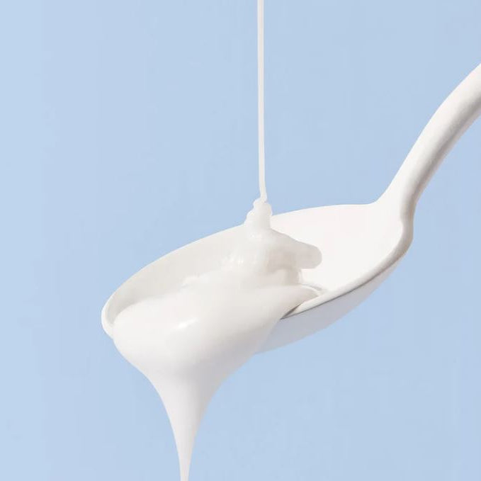 Spoon with a scoop of white cream against a light blue background