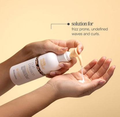 Hand holding a bottle of Zennelle Curl Passion product with a beige background