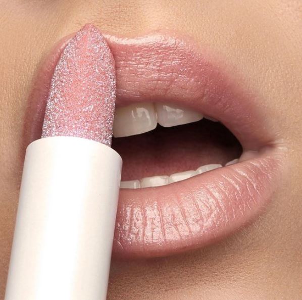 Close-up of a pink lipstick being applied to lips with a white handle.