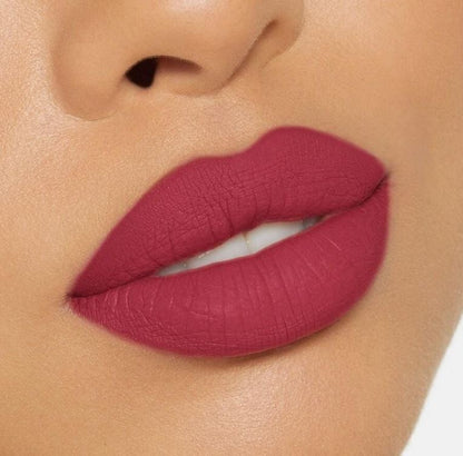 Close-up of a person wearing a vibrant pink lipstick on a neutral background