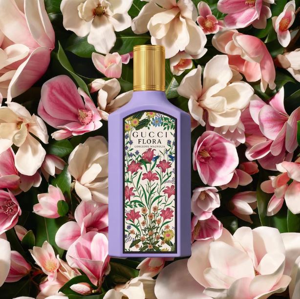 Gucci Flora perfume bottle surrounded by pink and white flowers