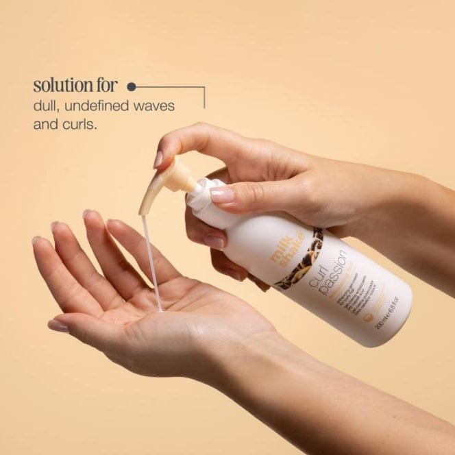 Hand holding a bottle of hair product with text on a beige background