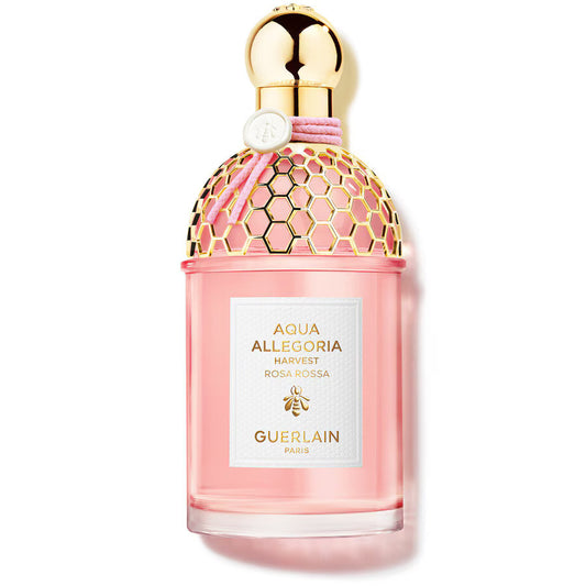 Pink Guerlain perfume bottle with gold cap on a white background