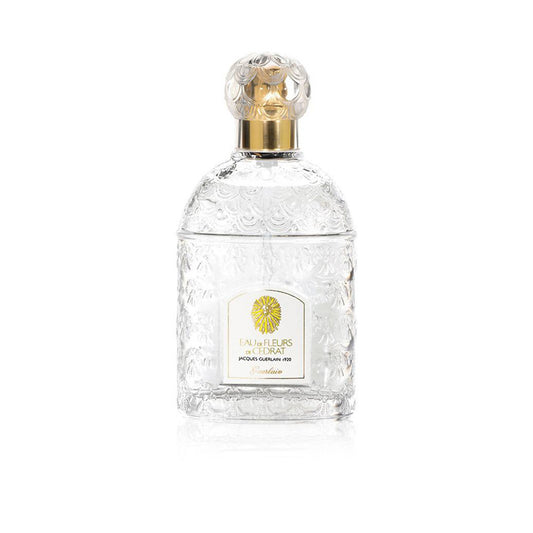 Clear perfume bottle with gold cap on a white background
