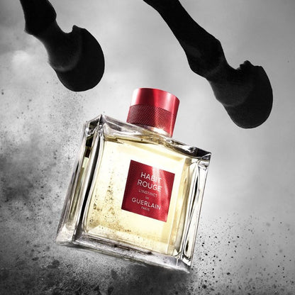 Perfume bottle with red cap and label on a textured surface