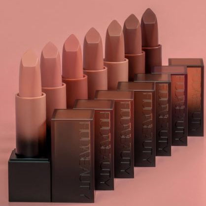 Set of lipsticks and their boxes on a pink background