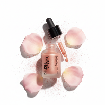 Rodial Blush Drops Sunset Kiss flat lay with rose petals and pink powder dust