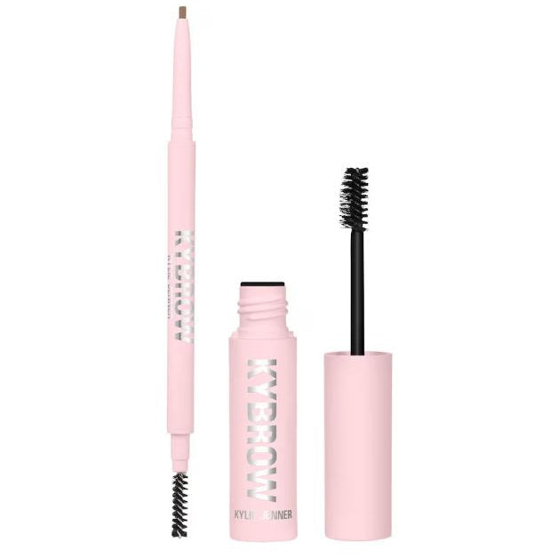 Makeup set with pink applicator, pink mascara, and black brush on a white background