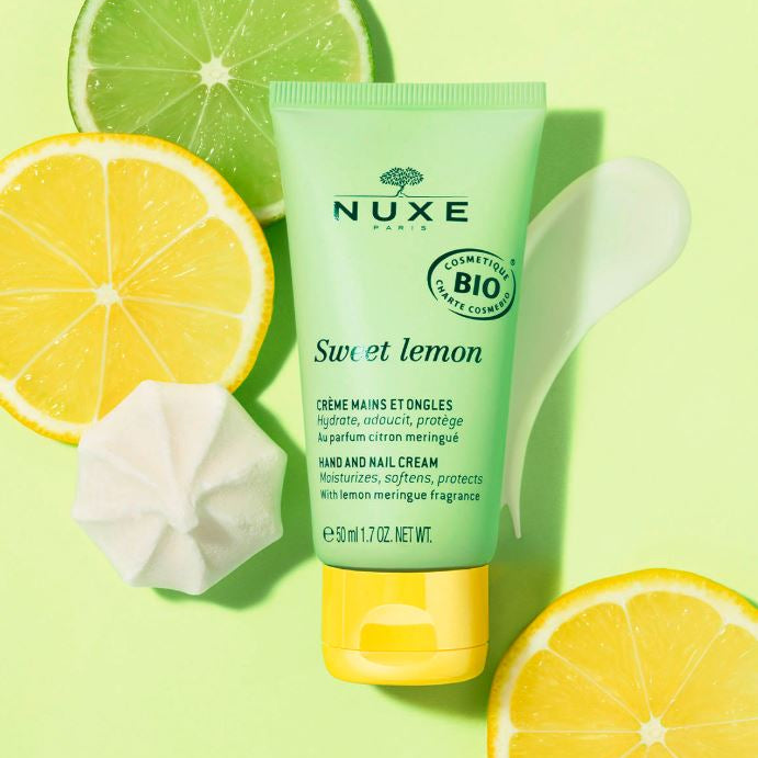 Nuxe Sweet Lemon hand and nail cream with lemon slices on a green background