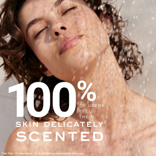 Person with a close-up of their face, water droplets on skin, and text about product scent.