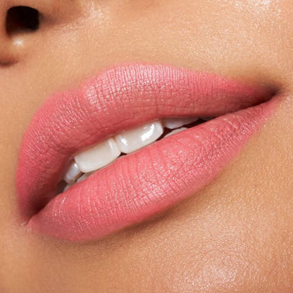 Close-up of a person's lips with pink lipstick on a neutral background