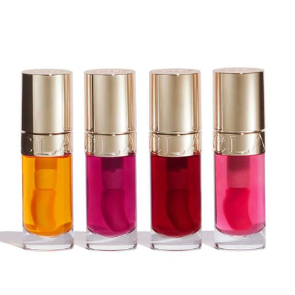 Four lip gloss bottles with gold caps on a white background