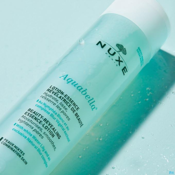 Nuxe Aquabella beauty-revealing essence-lotion bottle on a light blue background