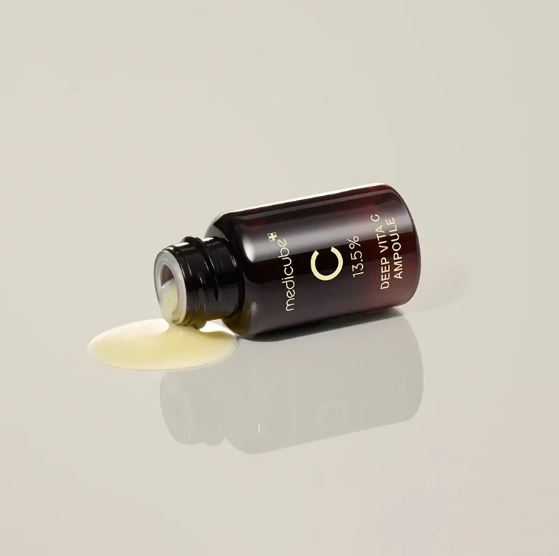 Medicinal dropper bottle with a beige liquid on a light gray background