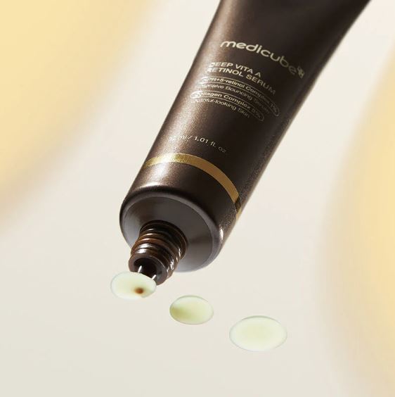 Medicube skincare product with cream being squeezed out on a light background