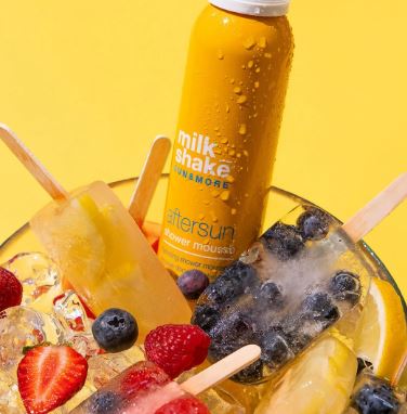 Milkshake with ice cream, berries, and popsicles on a yellow background