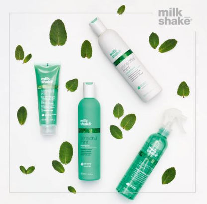 Milk Shake hair care products with green leaves on a white background