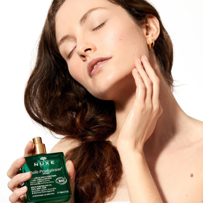 Woman holding a Nuxe product with a white background