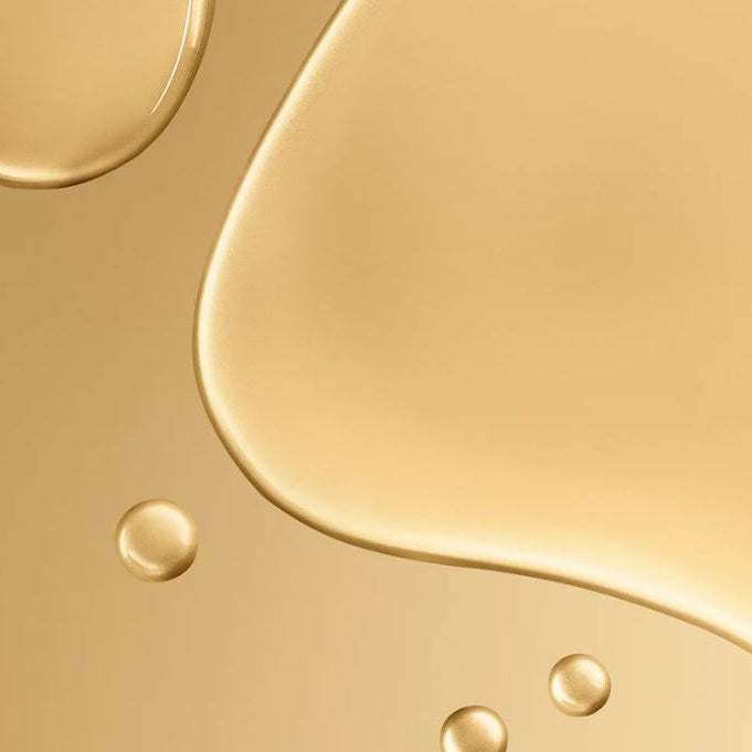 Close-up of gold liquid texture with droplets on a gold background