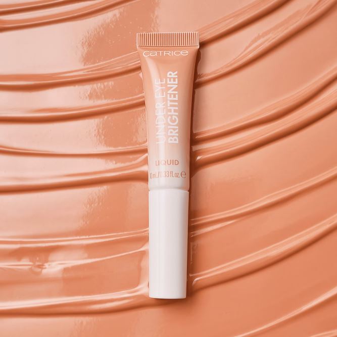 Catrice highlighter tube on a peachy background