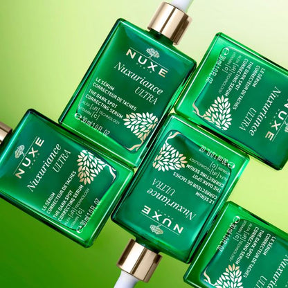 Nuxe Nuxuriance Ultra skincare serum bottles on a green background