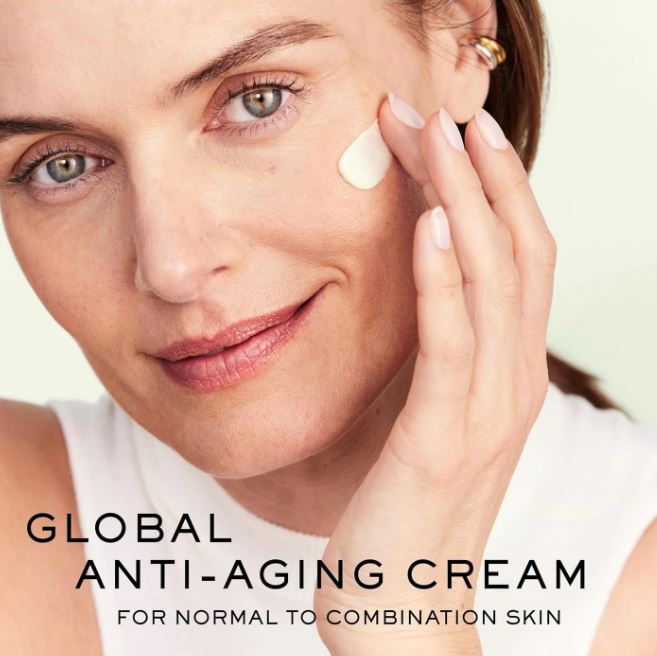 Woman applying cream to her face with text about global anti-aging cream for normal to combination skin.