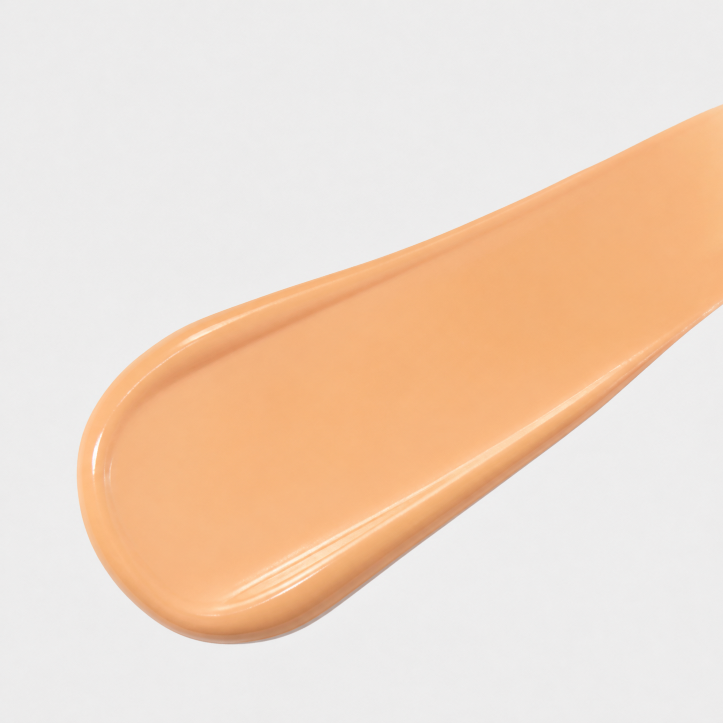 Close-up of a peach-colored cream on a gray background