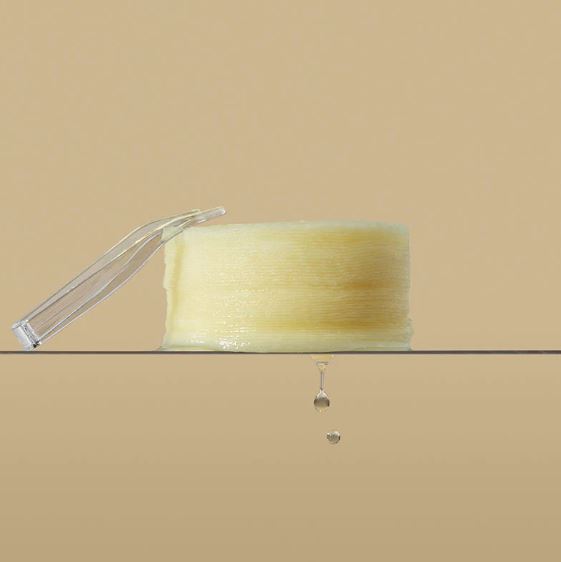 Transparent soap dish with a bar of soap on a beige background