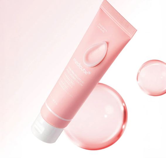 Pink skincare tube with a droplet design on a light pink background