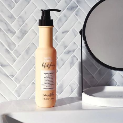 Hair product bottle on a marble surface with a mirror in the background