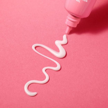 Pink bottle dispensing white gel on a pink background